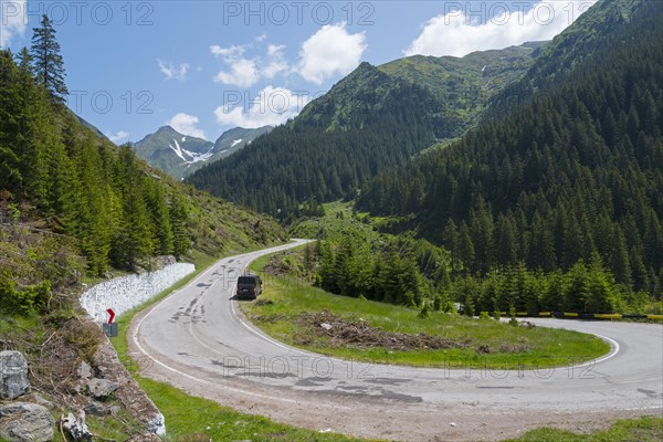 Camper on a winding mountain road, surrounded by forest and snow, mountain road, Transfogarasan high road, Transfagarasan, TransfagaraÈ™an, FagaraÈ™ Mountains, Fagaras, Transylvania, Transylvania, Transylvania, Ardeal, Transilvania, Carpathians, Romania, Europe