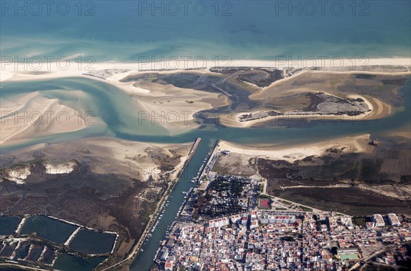 Aerial view of coastline near Faro, Algarve, Portugal showing settlements on coastal plain and offshore sand banks with sandy beaches running along the coast