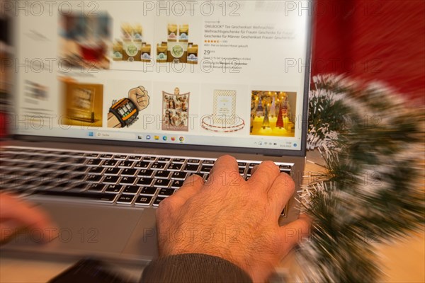 Symbolic image of Christmas shopping on the internet/at Amazon: Christmas decorations and laptop with open screen