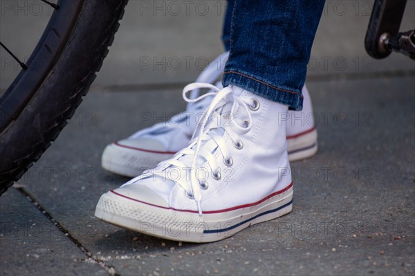 Woman wears white chucks and jeans