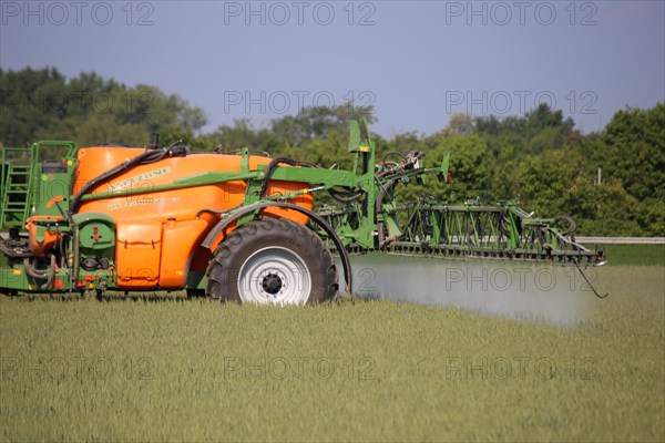 A farmer from the Schmitt vegetable farm in Hockenheim drives his tractor with a crop protection sprayer over his wheat field to combat brown rust and mildew (Hockenheim, Baden-Wuerttemberg)