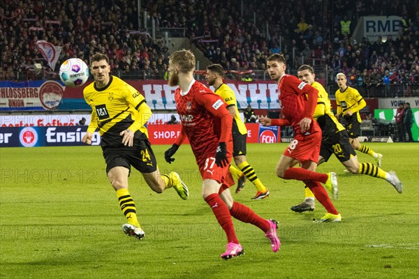 Football match, captain Patrick MAINKA 1.FC Heidenheim is pressurised by l.t.r. Nico SCHLOTTERBECK Borussia Dortmund, Niclas FUeLLKRUG Borussia Dortmund and Donyell MALEN Borussia Dortmund during a header, football stadium Voith-Arena, Heidenheim