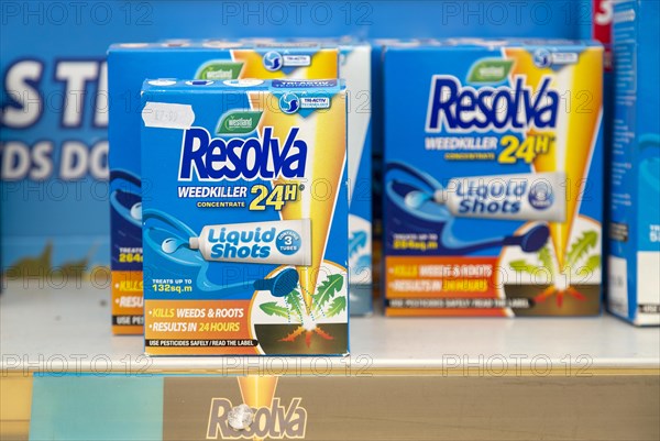 Cardboard boxes of Resolva weedkiller liquid shots 24 hour concentrate on shelf display in garden centre, UK