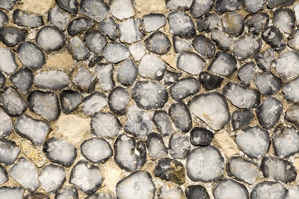 Dressed stone flint wall stonework facing flush work exterior of church of Saint John, Saxmundham, Suffolk, England, UK