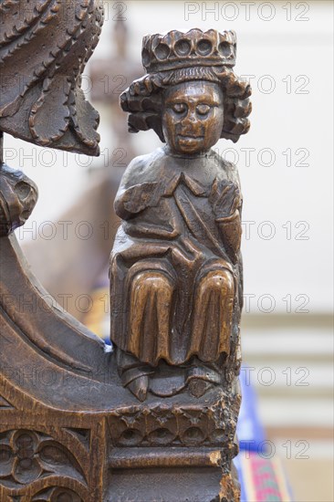 A seated King. Fifteenth century carved wooden pew bench ends of human figures and fantastical creatures, Ufford church, Suffolk, England, UK