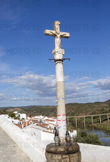 Historic cross crucifixion of Jesus Christ monument in medieval village with the Latin word oblatus, Mertola, Baixo Alentejo, Portugal, Southern Europe, Europe