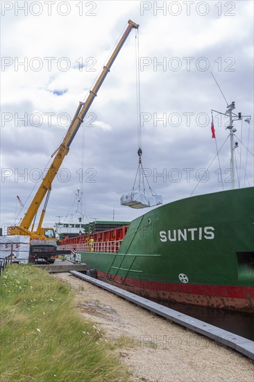 Crane unloading cargo ship Suntis at Anglo-Norden timber merchants, Wet Dock, Ipswich, Suffolk, England, UK