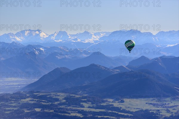 Hot air balloon flying in front of a mountain landscape, Montgolfiade Tegernsee Valley, Balloon Week Tegernsee, Bavarian Oberland, Upper Bavaria, Bavaria, Germany, Europe