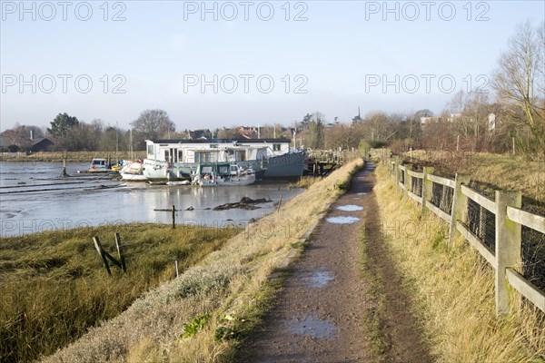 Houseboats moored by river wall River Deben, Melton, Suffolk, England, UK