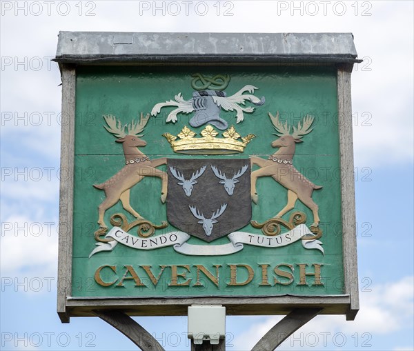 Village sign coat of arms heraldry, Cavendish, Suffolk, England, UK