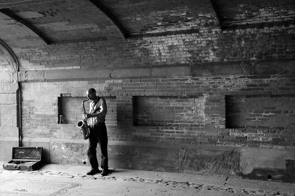 Saxophone player under a bridge in Central Park, New York City, USA, North America