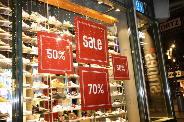 Shop window of the shoe shop Snipes in Mannheim with advertising for big discounts