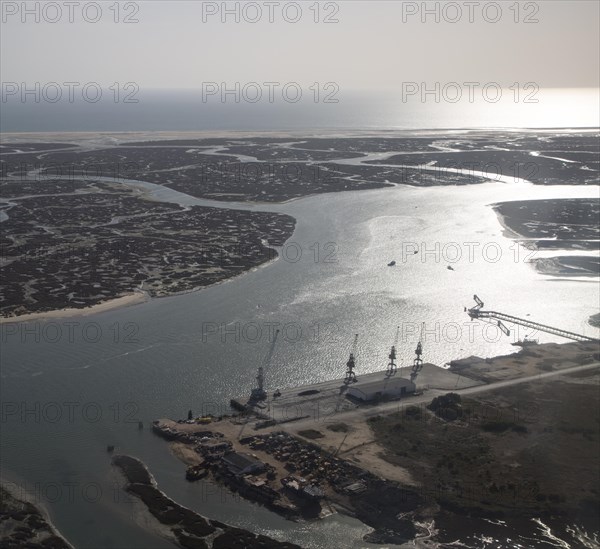 Coastal landscape of salt marsh and drainage channels along the coastline off Faro, Algarve, Portugal, Europe