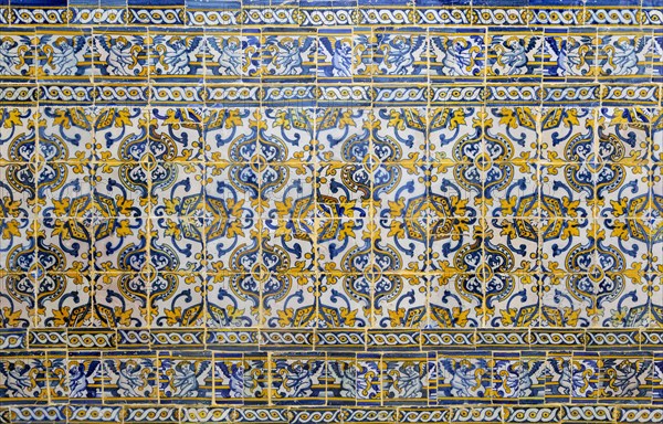Antique floral decorated Azulejo ceramic tiles in yellow, white and blue colours on wall inside a church, Evora, Alto Alentejo, Portugal, southern Europe, Europe