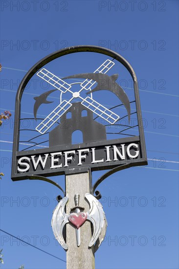 Village sign Sweffling, Suffolk, England, UK with swallow and windmill against blue sky