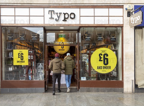 Sale at Typo store in city centre High Street shop, Exeter, Devon, England, UK, two people entering doorway