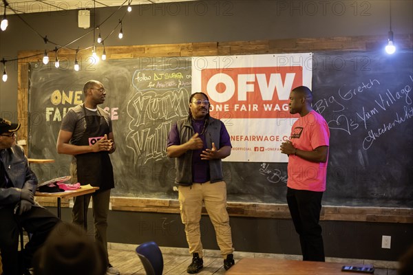 Detroit, Michigan USA, 8 February 2024, Michigan Lt. Governor Garlin Gilchrist spent an hour as a server at Yum Village restaurant to promote the campaign for One Fair Wage. Before serving, Gilchrist (left), Yum Village founder Godwin Ihentuge, and OFW Organizing Director Justin Onwenu talked about the importance of fair wages for restaurant workers. One Fair Wage works for a living minimum wage for all and the elimination of the sub-minimum wage for tipped workers. The endorsement of Governor Gretchen Whitmer, who stopped by earlier, is on the blackboard at right