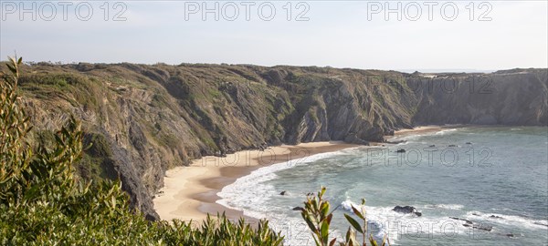 Secluded sandy beach in bay between rocky headlands at Parque Natural do Sudoeste Alentejano e Costa Vicentina, Natural Park, landscape panoramic view on the Ruta Vicentina long distance walking trail, at Praia dos Machados, Carvalhal, Alentejo Littoral, Portugal, southern Europe, Europe