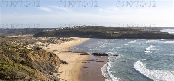 Panorama view of river mouth of Ribeira de Aljezur reaching the Atlantic Ocean and whitewashed buildings of Clero village, Aljezur, Algarve, Portugal, Southern Europe, Europe