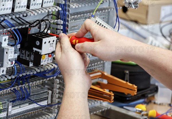 An electronics apprentice assembles a motor protection relay at a Deutsche Bahn training centre, Berlin, 07/02/2024