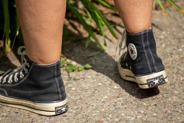 Close-up of black Chucks, worn by a young woman