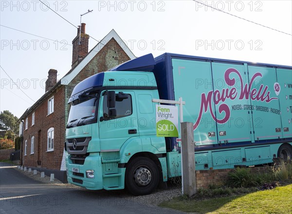 Removal van and estate agent sold sign next to house, moving in day, Shottisham, Suffolk, England, UK