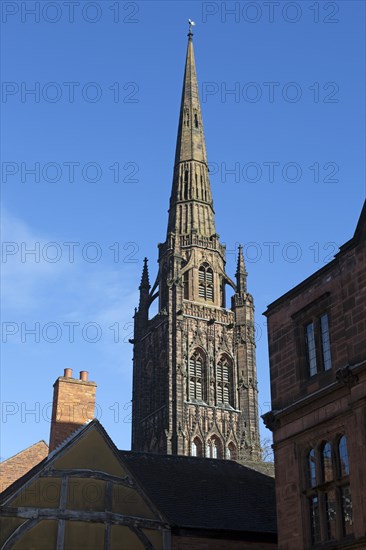 Steeple spire of old cathedral rising above historic buildings, Coventry, West Midlands, England, UK