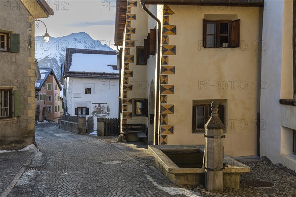Historic houses, sgraffito, facade decorations, historic village, mountain peaks with snow, winter, Guarda, Engadin, Graubuenden, Switzerland, Europe