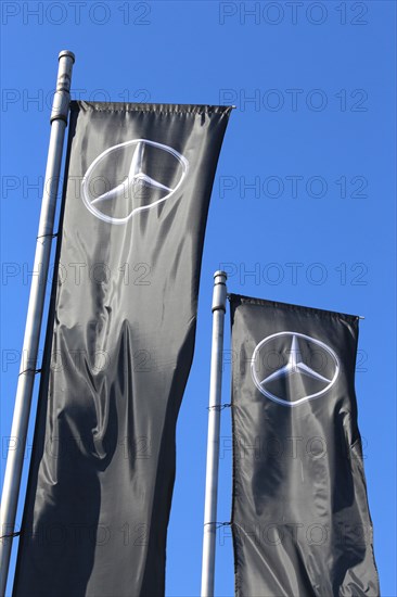 Flag with the Mercedes-Benz star against a blue sky