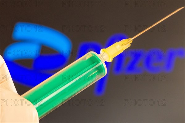 Corona vaccination/Pfizer symbol: close-up of an injection needle, with the Pfizer logo in the background. The debate about possible vaccine damage is currently gaining momentum in Germany