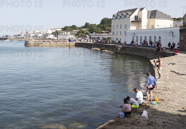 People crabbing from quayside, Swanage, Dorset, England, UK