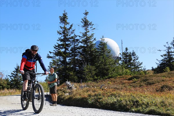 Mountain bike tour through the Bavarian Forest with the DAV Summit Club: Mountain bikers on the summit of the Grosser Arber 1, 456 metres above sea level