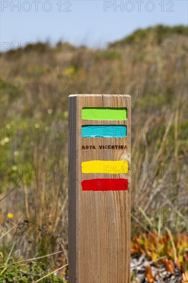 Footpath marker way mark sign painted in green, blue, yellow and red stripes for the Ruta Vicentina long distance footpath, the Fisherman's Trail and Historical Way, within the Southwest Alentejo and Vicentina Coast Natural Park, south west Portugal, southern Europe