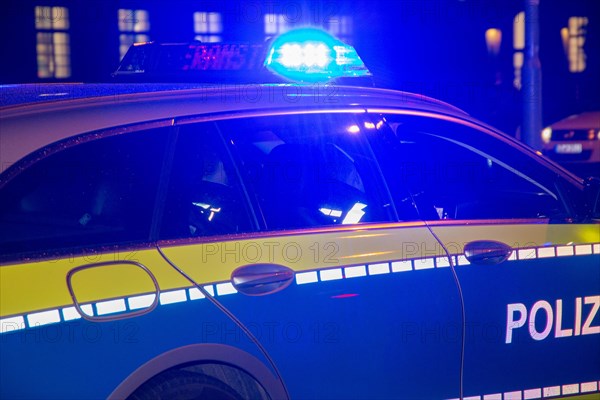 Symbolic image of a police operation: police vehicle in the dark