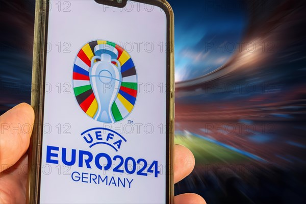 Symbolic image UEFA-EURO 2024: Smartphone with the EURO logo in front of a full stadium