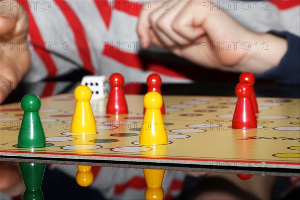 Symbolic image: Family playing Mensch aergere Dich nicht