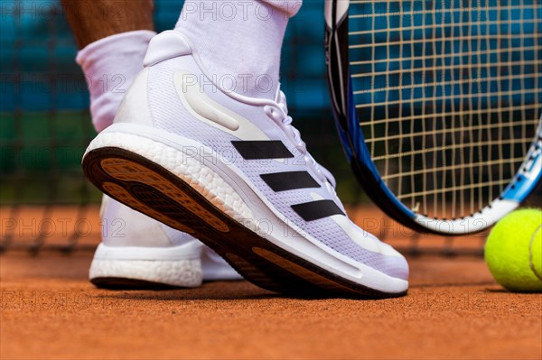 Symbolic image of tennis: close-up of a tennis player on a clay court