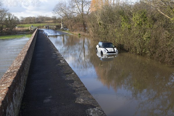 Mini Cooper S car stuck in River Avon flood water, Kellaways bridge, Wiltshire, England, UK 24/12/20