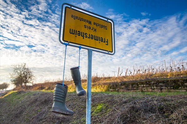 Freimersheim, Palatinate: Upside-down town sign with rubber boots as a symbol of the farmers' protests in Germany