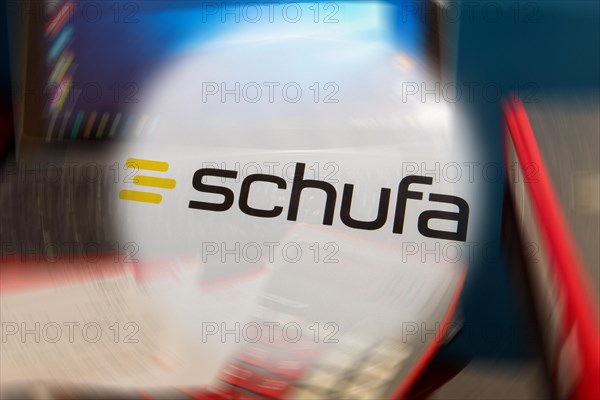 Symbolic image Schufa (information) : Schufa logo in front of a desk with tablet, calculator and account statements