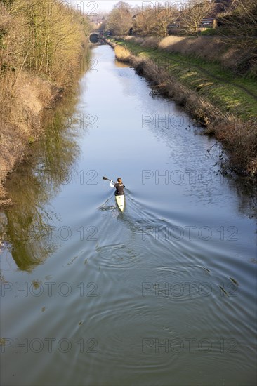 Female canoeist practising on Kennet and Avon canal, Devizes, Wiltshire, England, UK