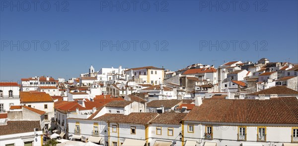 Panoramic style cityscape views over pan tile rooftops and whitewashed buildings in the city centre of Evora, Alto Alentejo, Portugal, southern Europe, Europe