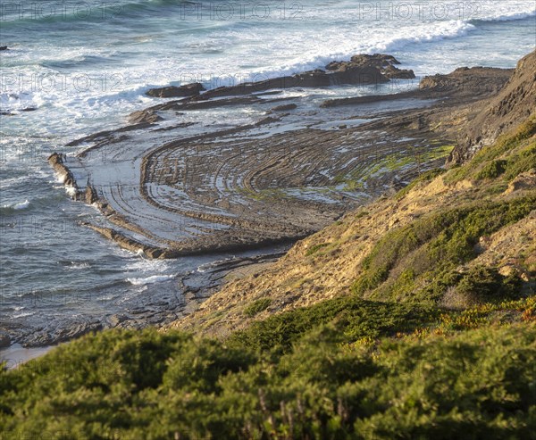 Intensely folded rock of wave cut platform. Rocky rugged coastal landscape on the Rota Vicentina Fisherman's Trail long distance footpath route, near Bunheira, Aljezur, Algarve, Portugal, Southern Europe, Europe
