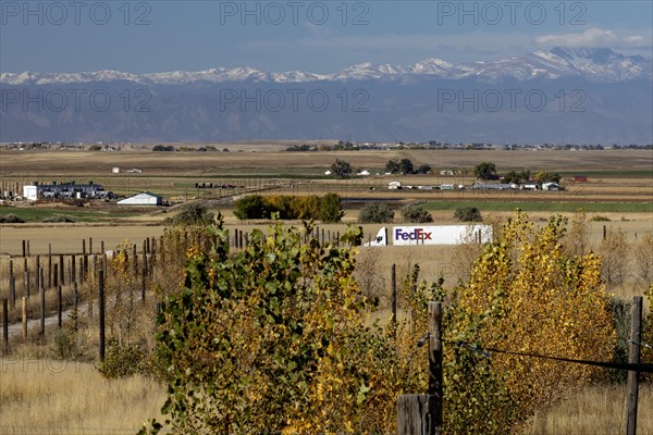 Keenesburg, Colorado, A FedEx truck on a rural road on Colorado's eastern plains, with the Rocky Mountains in the distance