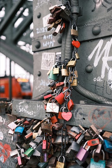 Love locks on a bridge over the Rhine, behind it a railway, blurred background, Cologne, Germany, Europe