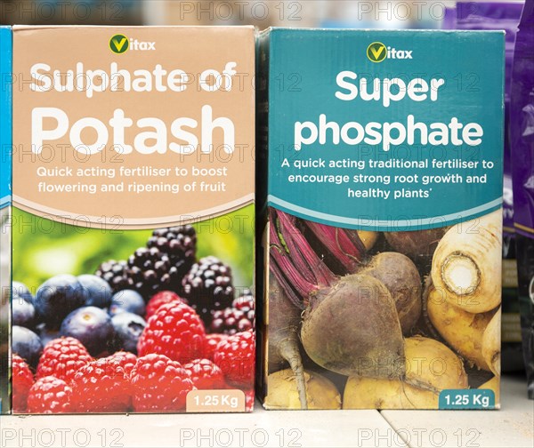 Cardboard boxes of Vitax Sulphate of Potash and Super Phosphate on shelf display in garden centre, UK