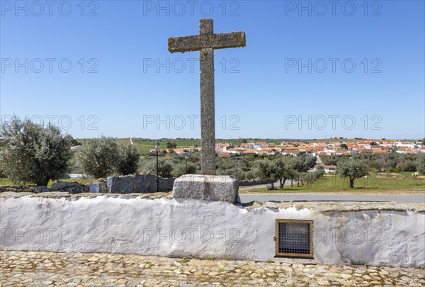 View of buildings rural country village from church Igreja Santa Barbara de Padroes, near Castro Verde, Baixo Alentejo, Portugal, southern Europe overlooking olive trees and standing stone cross, Europe
