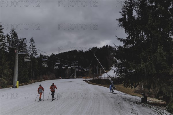 Two ski instructors go on a ski tour, taken on a ski slope in the Jizera Mountains ski area near Albrechtice v Jizerskych Horach, 05.02.2024. The Czech low mountain range with its ski area is affected by increasingly warmer and shorter winters