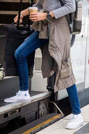 Woman wears white chucks and jeans