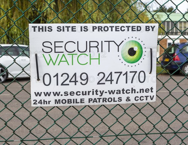 Security protection sign on wire fence, Porte Marsh Industrial Estate, Calne, Wiltshire, England, UK
